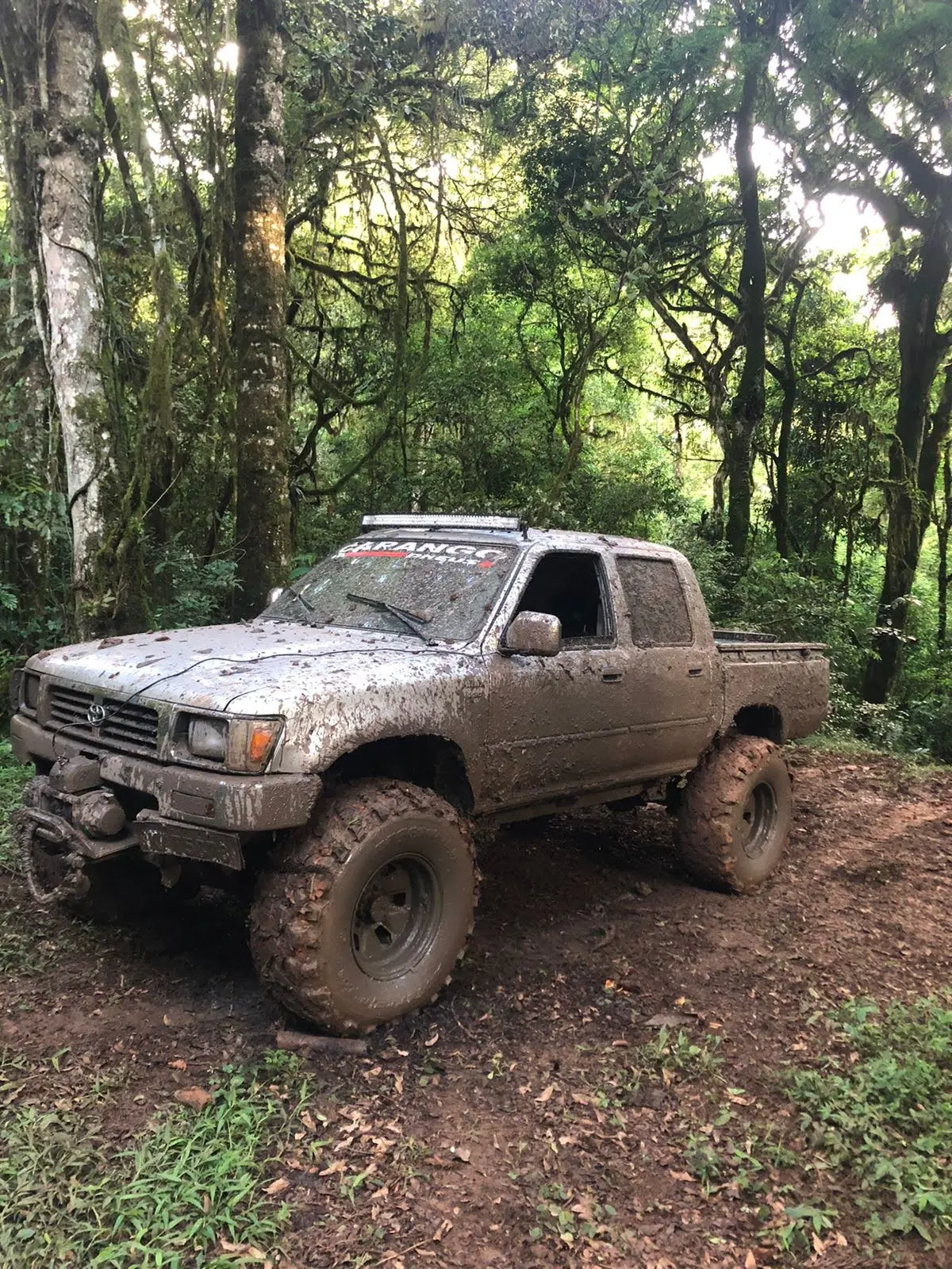 Caminhonete 4x4 com pneus Comando 2 em trilha na mata