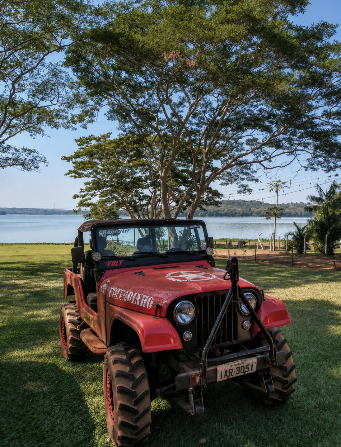 Jeep vermelho equipado com pneus Dardara próximo a um lago