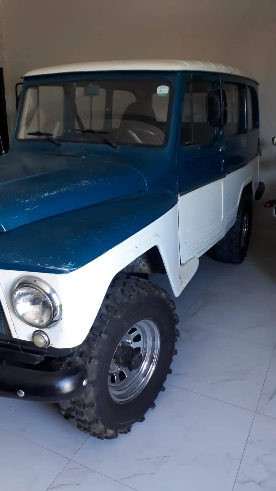 Jeep clássico azul e branco equipado com pneus Mamute