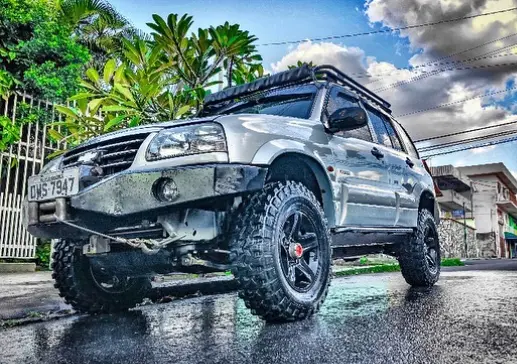 SUV prata equipado com pneus Mud em piso molhado