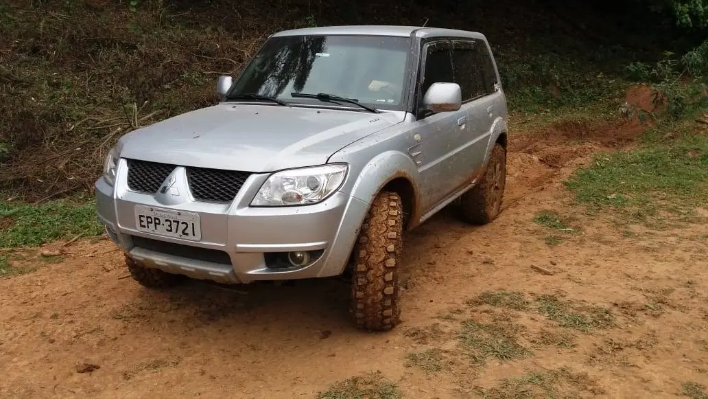 SUV prata equipado com pneus Mud em estrada de terra